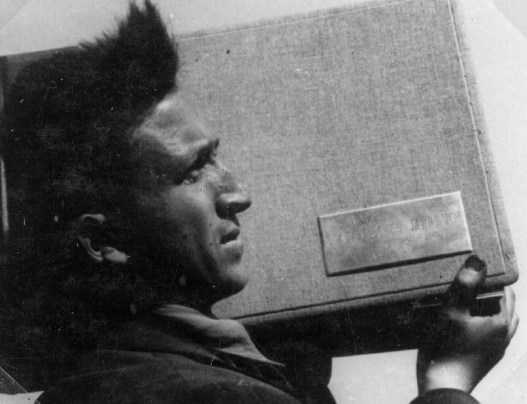 The photographer Mendel Grosman, carrying on his shoulder an album he prepared for the Judenrat of the Lodz ghetto.